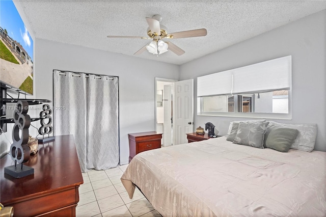 tiled bedroom featuring ceiling fan and a textured ceiling