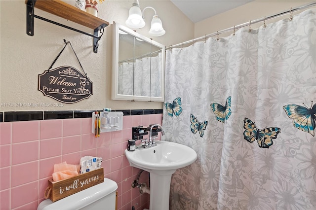 bathroom with tile walls and toilet