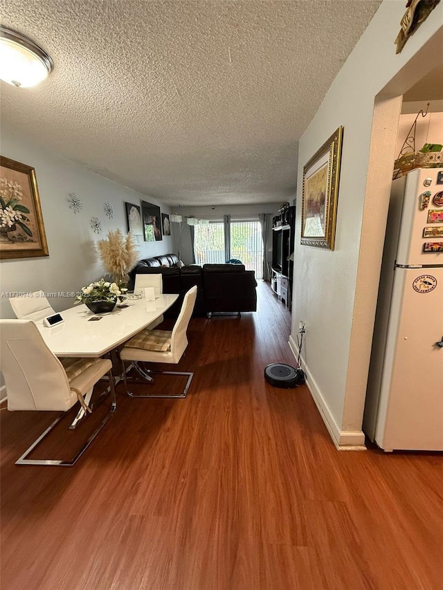 dining area featuring hardwood / wood-style floors and a textured ceiling