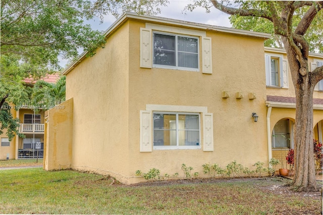 view of home's exterior with a lawn and stucco siding