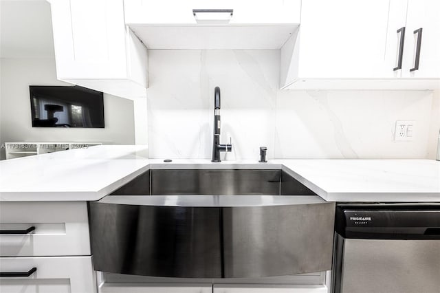 kitchen featuring sink, tasteful backsplash, light stone counters, white cabinets, and stainless steel dishwasher