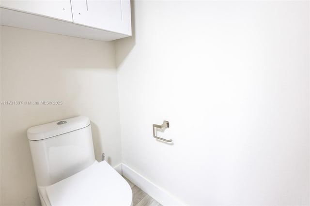 bathroom with wood-type flooring and toilet