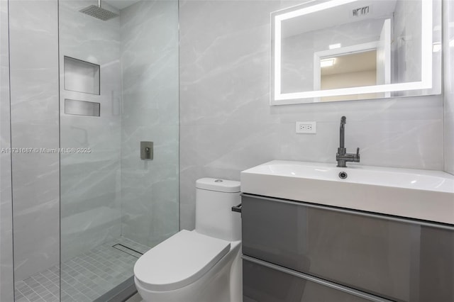 bathroom featuring tiled shower, toilet, tile walls, vanity, and backsplash