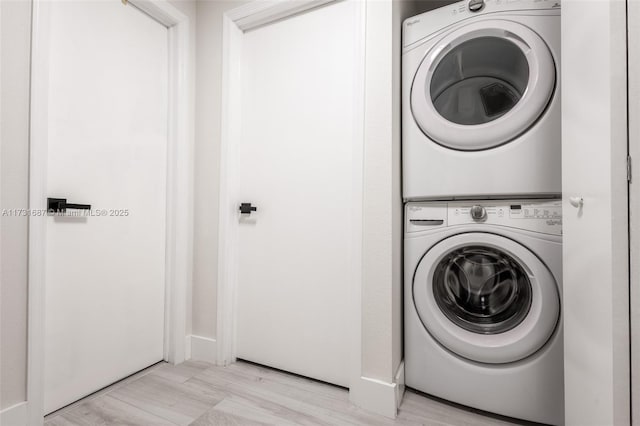 washroom featuring stacked washer / drying machine and light hardwood / wood-style flooring