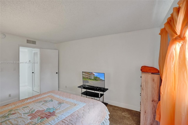 bedroom featuring a textured ceiling and carpet