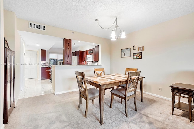 carpeted dining room featuring a textured ceiling and a chandelier