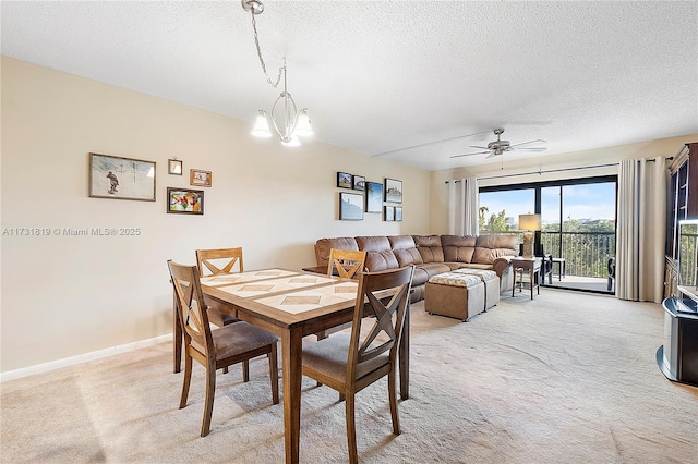 dining room with ceiling fan with notable chandelier, light carpet, and a textured ceiling