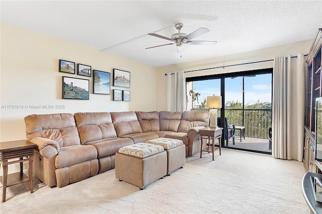 carpeted living room featuring ceiling fan and a textured ceiling