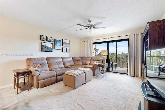 living room with ceiling fan, light colored carpet, and a textured ceiling