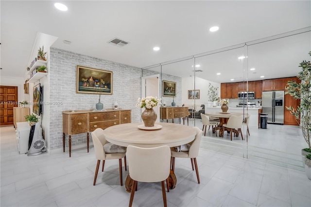 dining space featuring brick wall