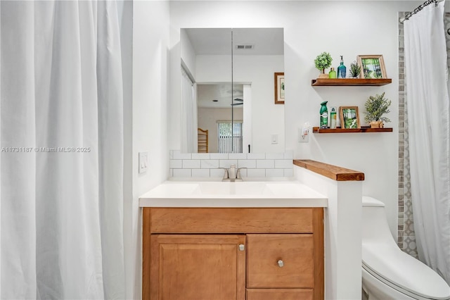 bathroom with tasteful backsplash, vanity, and toilet