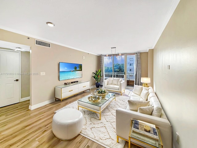 living room with crown molding, a wall of windows, and light hardwood / wood-style flooring