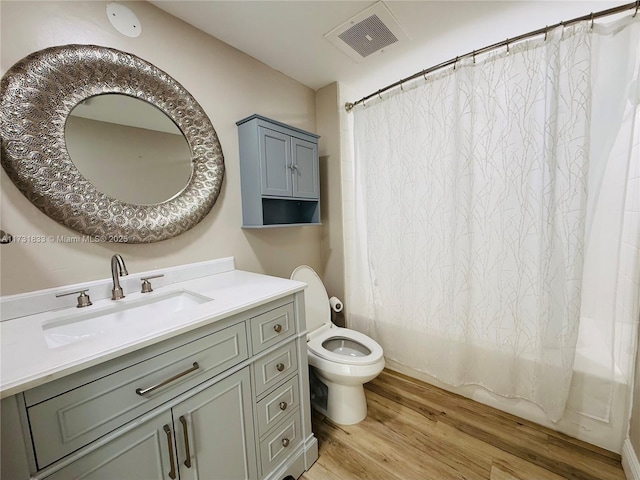 full bathroom featuring vanity, hardwood / wood-style floors, shower / bath combo with shower curtain, and toilet