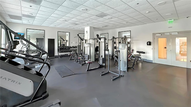 exercise room featuring a drop ceiling and french doors