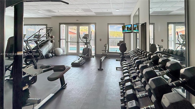 exercise room with a paneled ceiling and french doors