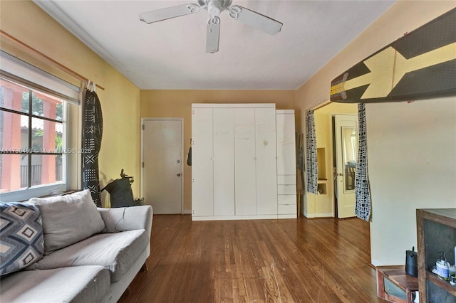 living room featuring ceiling fan and dark hardwood / wood-style flooring