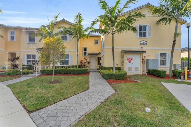 multi unit property featuring a front yard and stucco siding