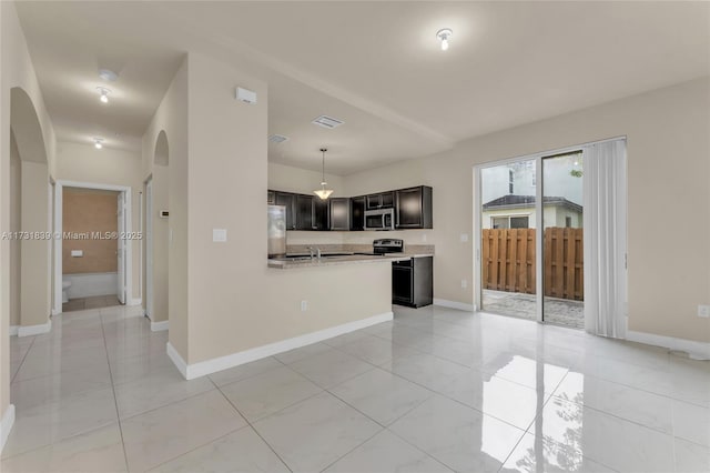 kitchen featuring arched walkways, visible vents, light countertops, appliances with stainless steel finishes, and hanging light fixtures