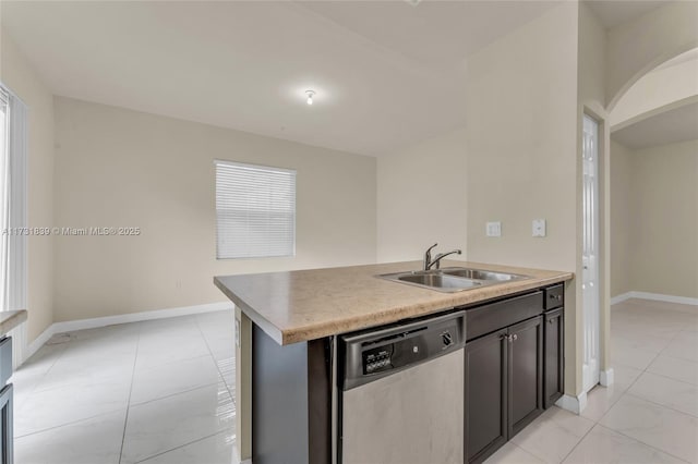 kitchen with baseboards, arched walkways, dishwasher, light countertops, and a sink