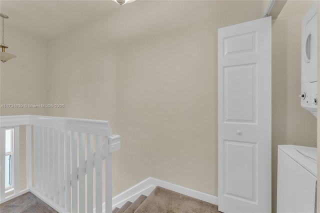 clothes washing area with stacked washer and dryer, laundry area, and baseboards