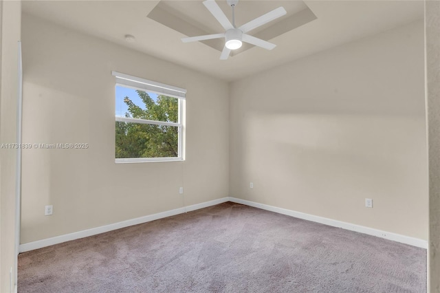 carpeted empty room featuring ceiling fan and baseboards