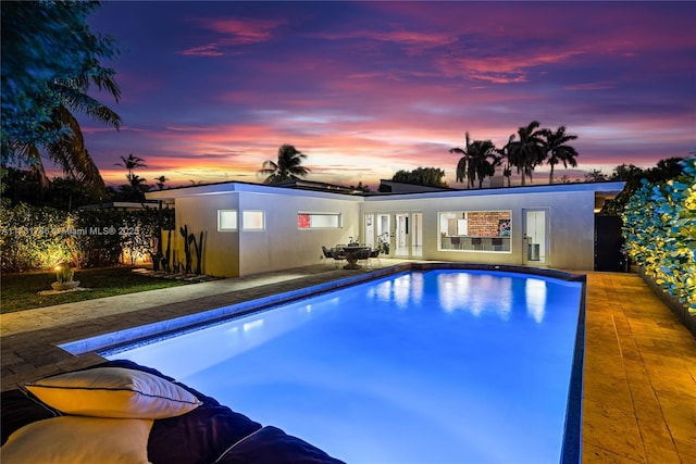 pool at dusk with a patio