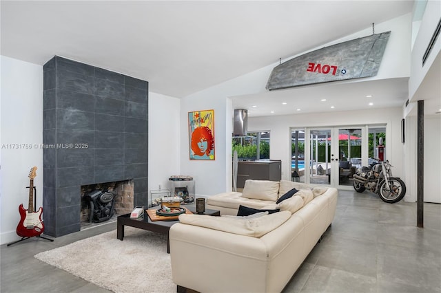 living room featuring french doors, a healthy amount of sunlight, a fireplace, and vaulted ceiling