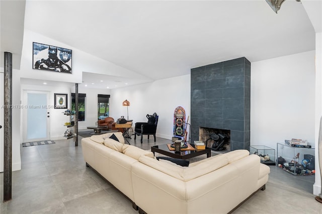 living room featuring a tiled fireplace and high vaulted ceiling