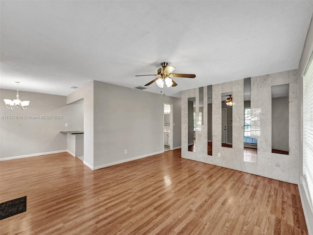 unfurnished living room with hardwood / wood-style floors and ceiling fan with notable chandelier