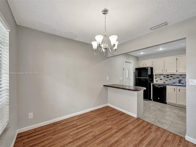 kitchen with decorative light fixtures, black appliances, light hardwood / wood-style floors, decorative backsplash, and white cabinets