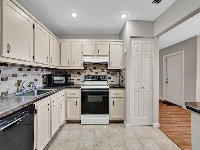 kitchen featuring sink, light tile patterned floors, backsplash, and black appliances