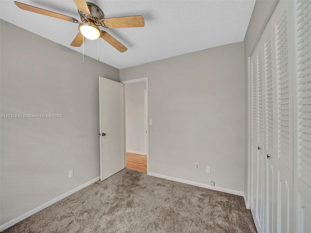 unfurnished bedroom featuring ceiling fan, a closet, carpet, and a textured ceiling