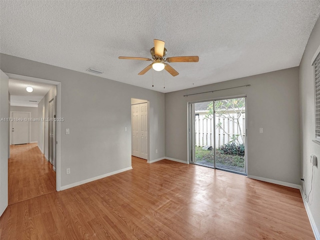 unfurnished room with a textured ceiling, light hardwood / wood-style floors, and ceiling fan