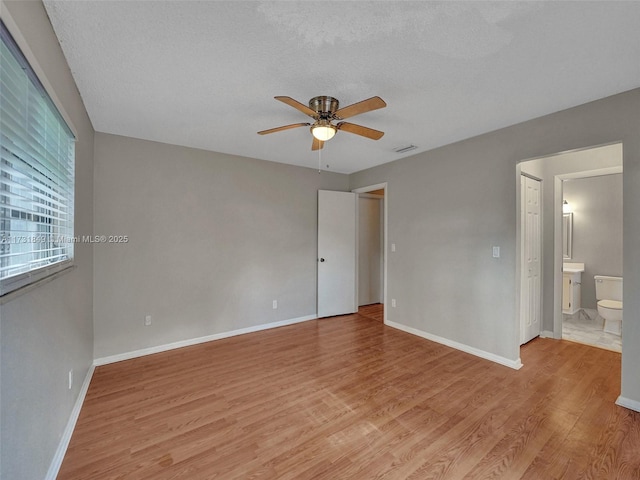 unfurnished room featuring ceiling fan, light hardwood / wood-style flooring, and a textured ceiling