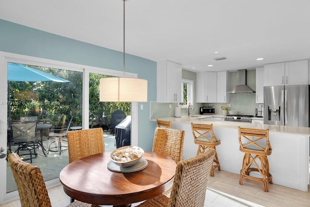 dining area with sink, light tile patterned floors, and plenty of natural light