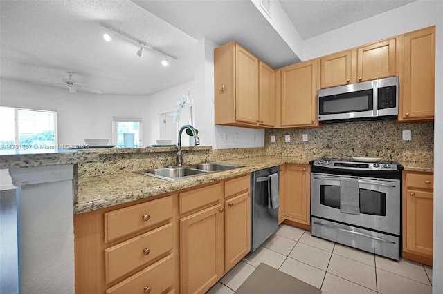 kitchen with sink, decorative backsplash, kitchen peninsula, stainless steel appliances, and a textured ceiling