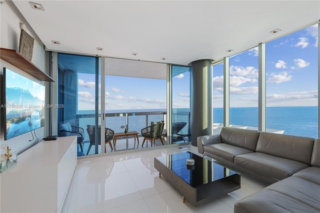 tiled living room with a water view, a wall of windows, and a healthy amount of sunlight