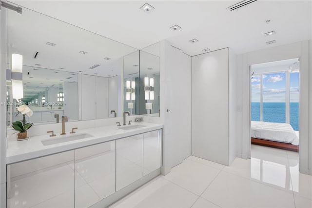 bathroom with tile patterned flooring, vanity, and a water view