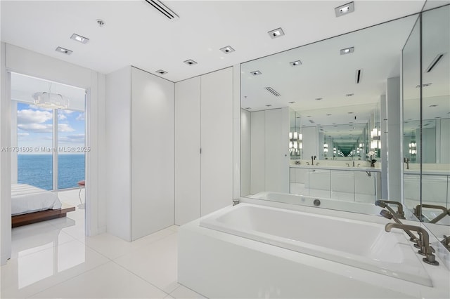 bathroom with vanity, a bathtub, tile patterned floors, and a water view