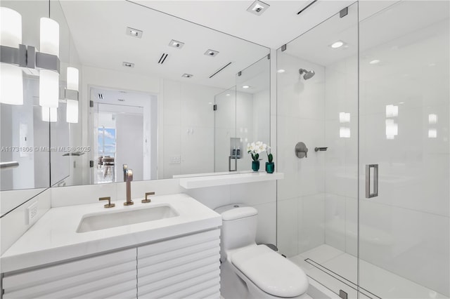 bathroom featuring vanity, a shower with door, tile walls, and toilet