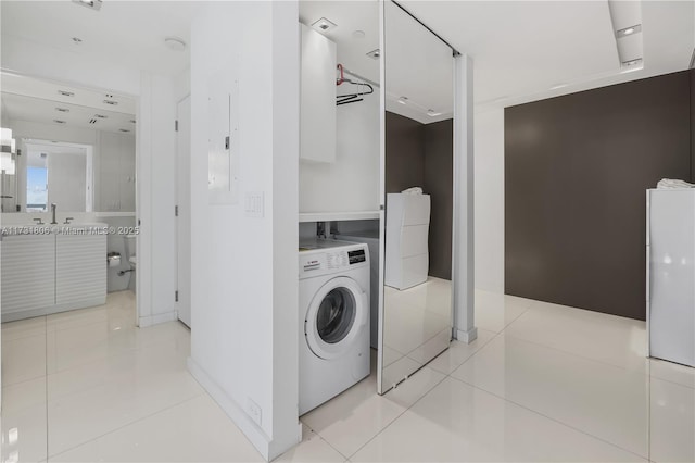 laundry room with washer / clothes dryer, sink, and light tile patterned flooring