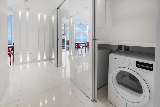 clothes washing area featuring light tile patterned floors and washer / dryer