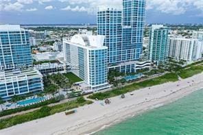 birds eye view of property featuring a water view and a beach view