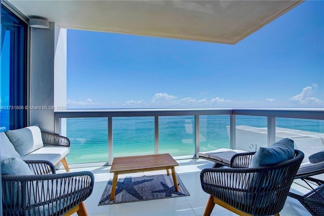 balcony featuring an outdoor hangout area, a beach view, and a water view