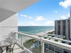 balcony featuring a water view and a view of the beach