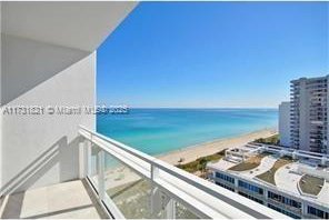 balcony with a water view and a view of the beach