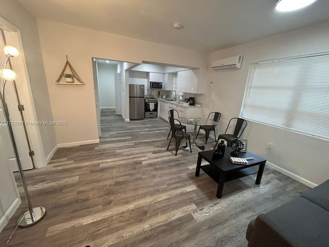 dining area with dark wood-type flooring, sink, and a wall unit AC