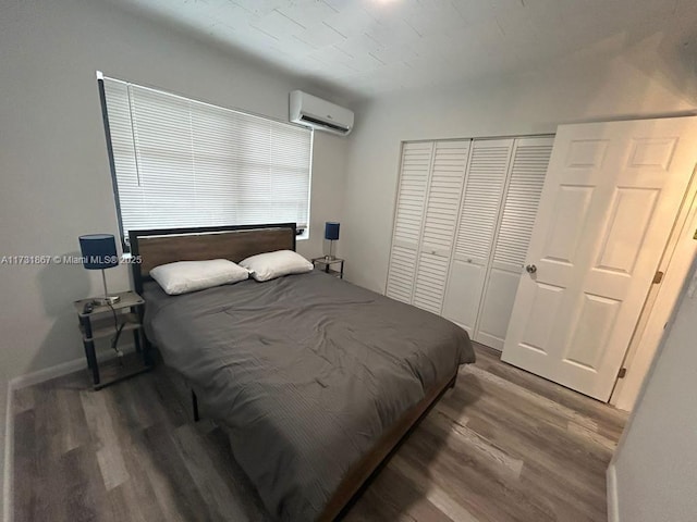 bedroom featuring hardwood / wood-style flooring and a wall mounted AC