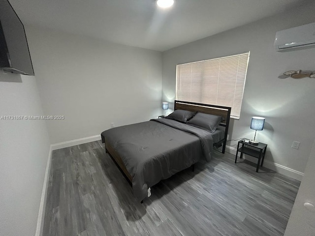 bedroom with dark hardwood / wood-style flooring and an AC wall unit