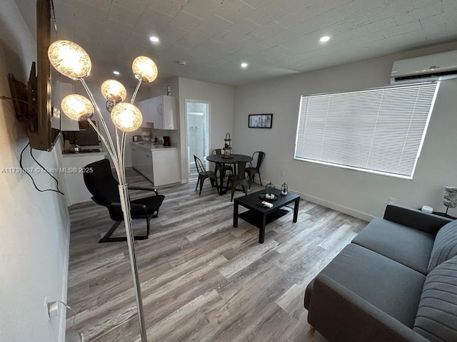 living room with a wall mounted air conditioner and light wood-type flooring